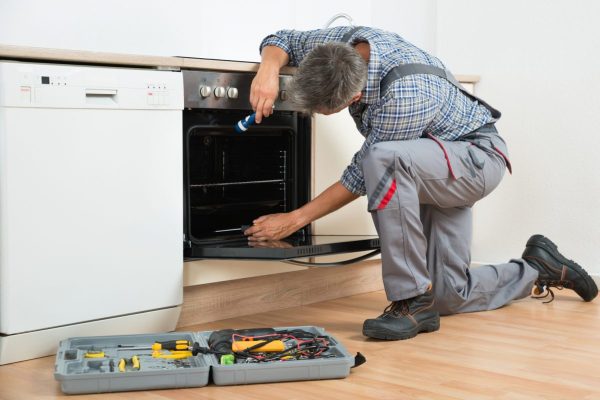 bigstock-Repairman-Examining-Oven-With-106442591-1199x800